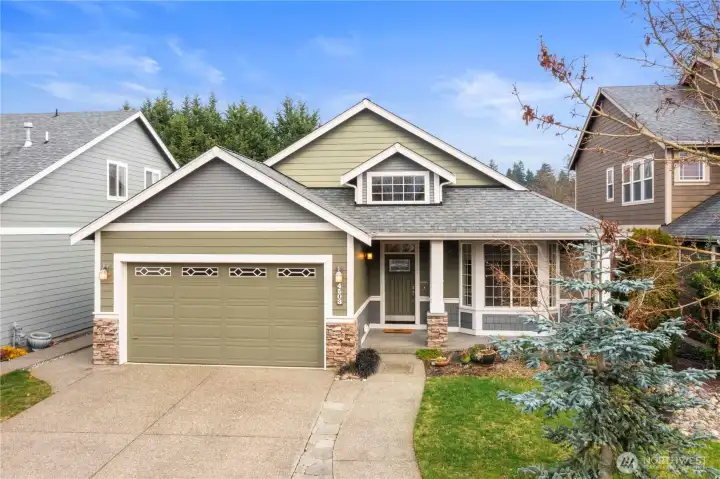 Classic curb appeal featuring a covered porch and attached two-car garage.