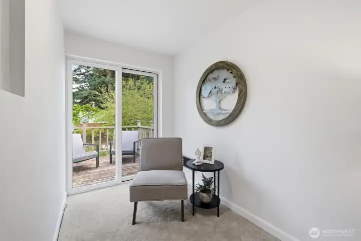 Cozy nook in primary bedroom that leads to private deck.