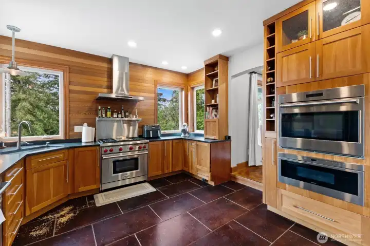 Double oven, gas range, wolf appliances in a naturally bright kitchen