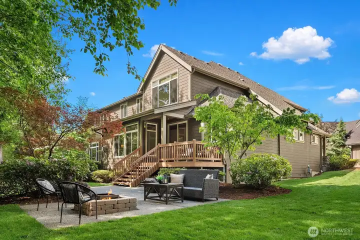 Enjoy NW living with a covered porch, paved patio, and a built-in fire pit and a massive backyard that borders the serene greenbelt