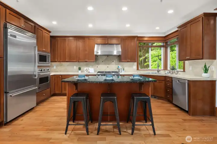 Gourmet chef’s kitchen features top-of-the-line Viking stainless steel appliances, a gas cooktop, custom cabinetry, and a granite center island with an eat-up bar