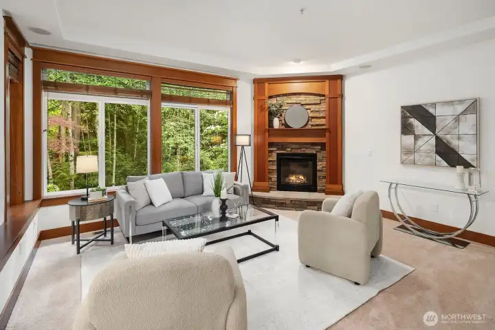 Family room with stone-hearth fireplace with picturesque views of the lush, protected greenbelt.