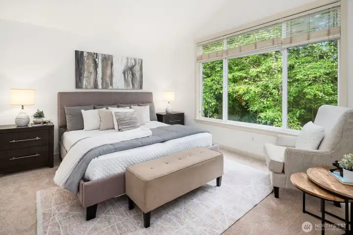 Primary suite with vaulted ceilings, expansive windows that frames serene views of the greenbelt