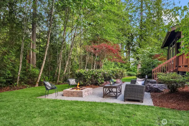 Serene backyard, paved patio, and a built-in fire pit