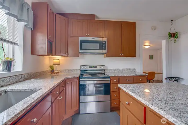 Updated kitchen with slab granite counters, cherry cabinets, center island, and farm sink
