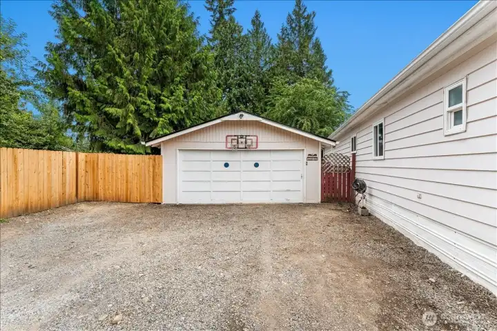 A detached two-car garage is complemented by generous off-street parking for vehicles, RVs, trailers, or guests.