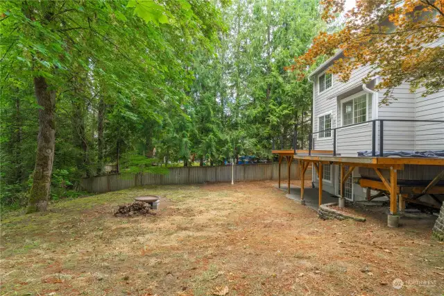 View of the large and private backyard, complete with a firepit area. You can walk down through the woods to the creek below. Waterfront without the taxes!