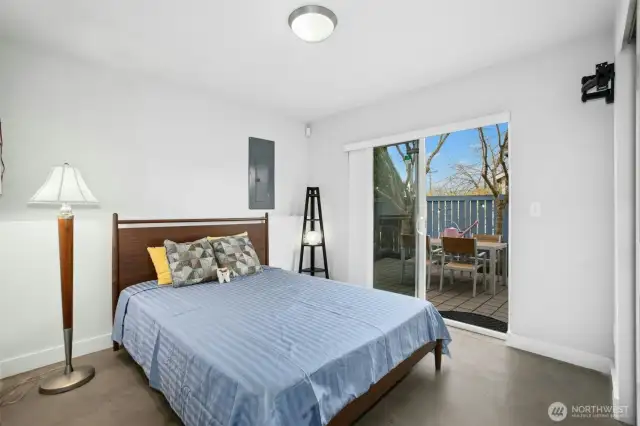 Lower-level bedroom with sliders onto patio.