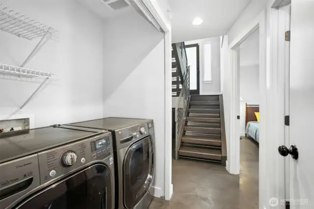 LG washer-dryer on lower level. Entry door is up those stairs. Photographer standing at garage door.