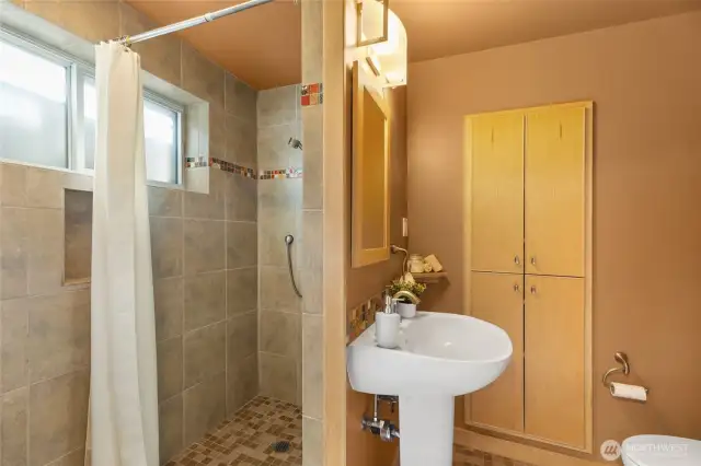 Three-quarter bathroom that is perfect for dog washing after a trip to the dog park!