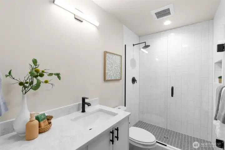 Luxurious en-suite bath with dual vanity and sleek tile finishes.