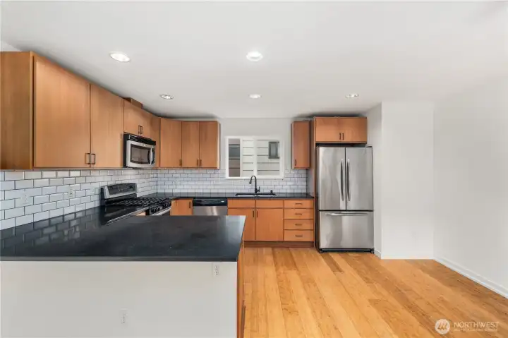 Slab granite peninsula bar has seating area for 3