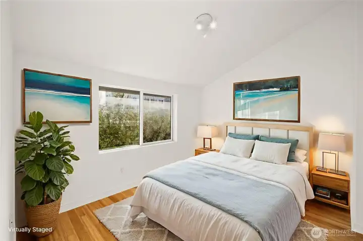 Primary bedroom with vaulted ceilings. Virtually staged