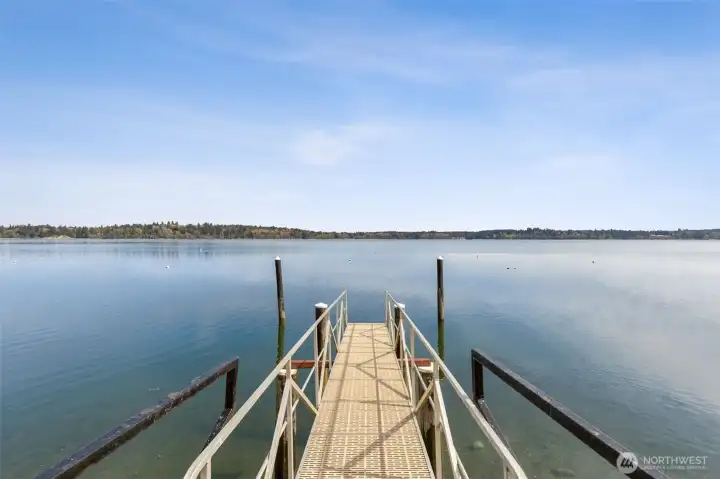 Standing here, you start to understand what makes this neighborhood so sought after. The private dock walkway gives you that easy, direct connection to Budd Inlet, where boating out to Olympia becomes part of the routine instead of a special occasion. Cruise over to the marina, grab dinner on the waterfront, or just take a slow evening ride as the sun drops behind the hills. The setting here does a lot of the work for you, wide open water, big sky, and that calm, coastal feel that defines this part of the South Sound.