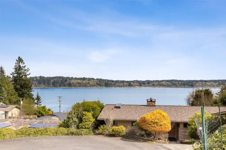 Even from the driveway, the setting delivers. Looking out toward Budd Inlet from this slightly elevated vantage point, you get a clear, calming water view that immediately sets the tone for the property. Being tucked into a cul-de-sac keeps traffic to a minimum, so it stays quiet and easy to enjoy. One of the real advantages here is getting all the visual payoff of waterfront living without the added tax hit that usually comes with it. And with private neighborhood access to the dock and beach, you’re not missing out on the lifestyle, just skipping the extra expense. It’s a pretty smart balance.