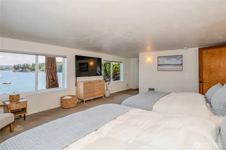 Lower level primary with 3/4 bath on far right as well as a walk out to a patio area.