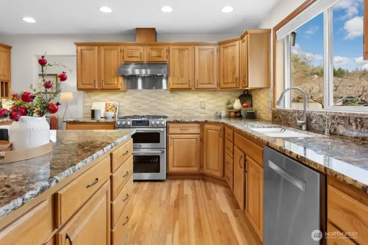 The gourmet kitchen overlooks the beautifully landscaped backyard