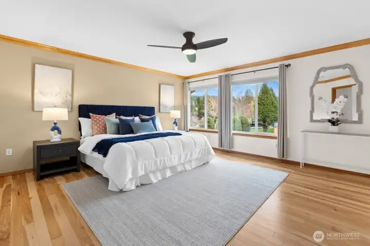 Large primary suite with loads of light and engineered hardwood flooring