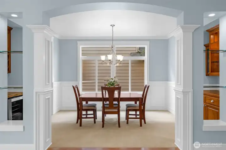 The elegant formal dining room showcases classic wainscoting and refined millwork, complemented by a stylish wine bar—perfect for hosting intimate dinners and sophisticated gatherings.