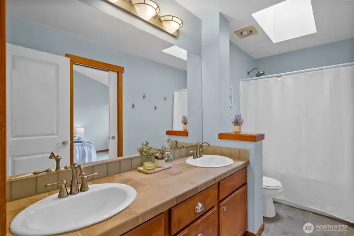 Full bathroom with skylight for natural light. This bathroom has a door to the hallway and a pocket door to the second bedroom.