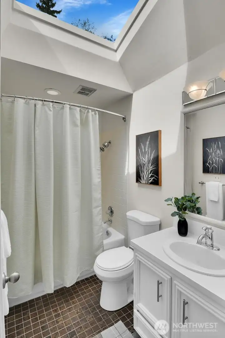 The shared bathroom on the upper floor has a skylight and a linen closet.