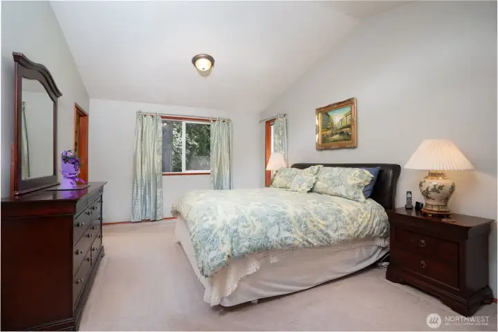 Primary suite with vaulted ceilings fits a king sized bed & has a large closet.