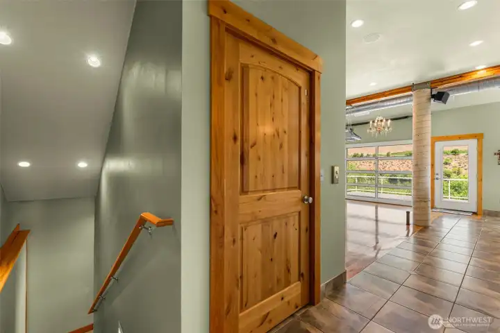 When entering from the double garage, there are the choices of stairs to the lower floor or the 3 floor elevator.