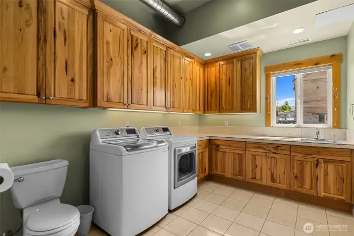 The main floor laundry room and one of the 1/2 baths is located to your immediate right, before entering the kitchen/dining/living area.  Notice the abundance of high end cabinetry through out. All made of solid knotty hickory.