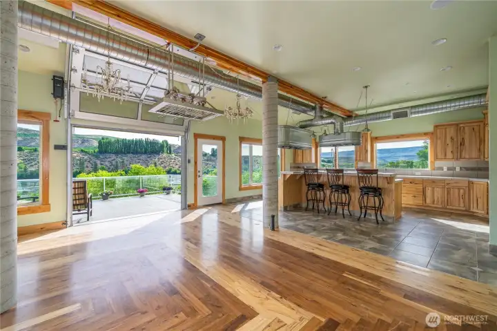 The knotty Hickory cabinets included in the Kitchen are complimented with the matching flooring in dining and living rooms.  Flooring in the kitchen is heated tile for function, comfort and practicality.  The overhead doors bring in the out of doors!