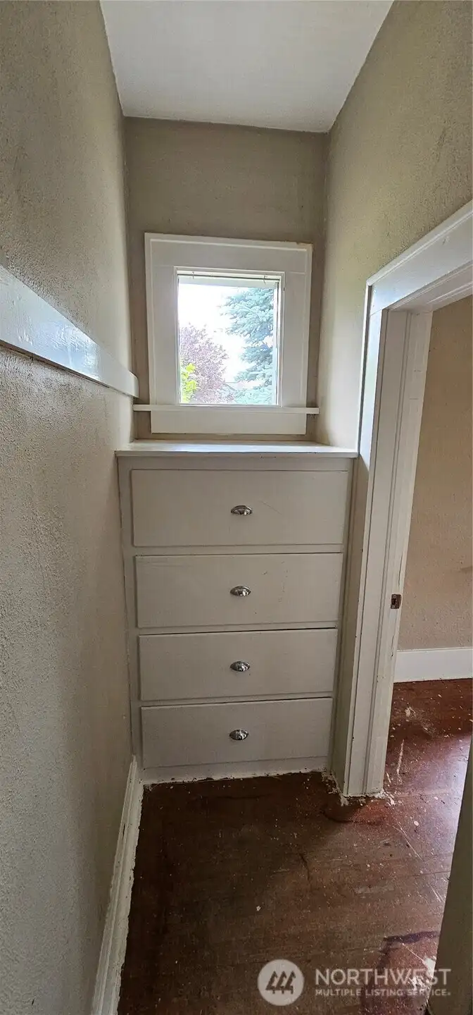 Closet has a window and built-in dresser, plus hanging space.