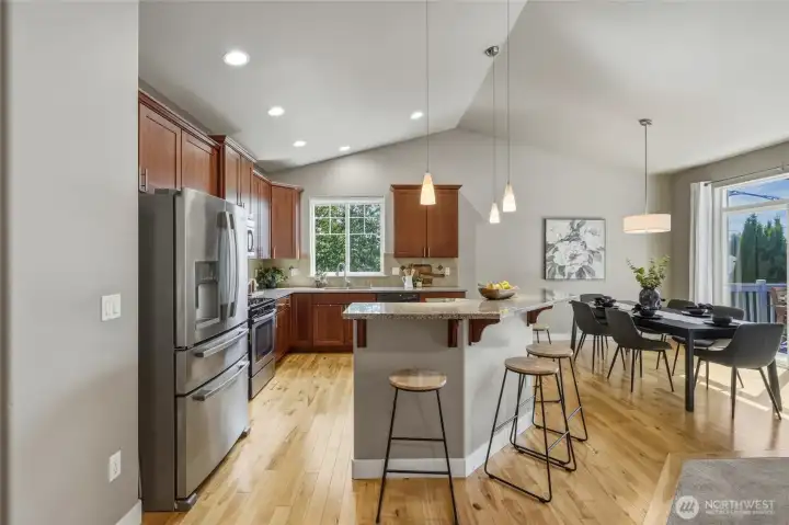 Kitchen with granite countertops, stainless steel appliances, and an eating bar.