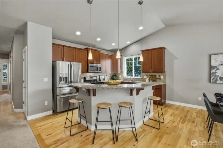Open kitchen featuring granite countertops, stainless steel appliances, and an island.