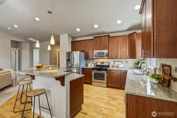Granite countertops, stainless steel appliances, ample cabinetry, and an eating bar.
