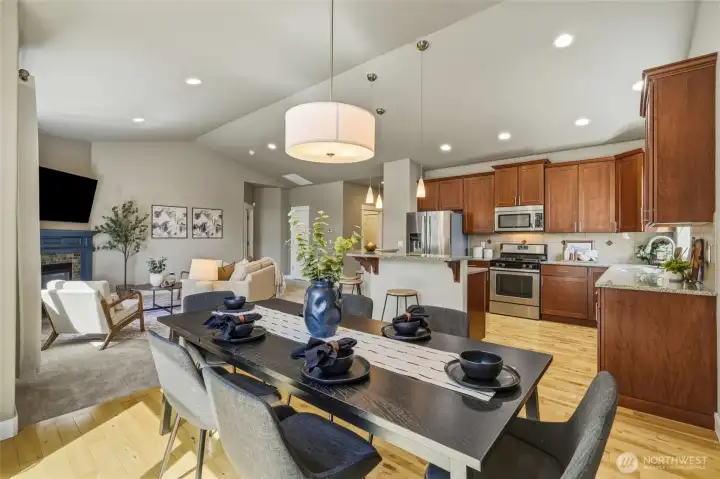 Open-concept kitchen, dining, and living areas with vaulted ceilings.