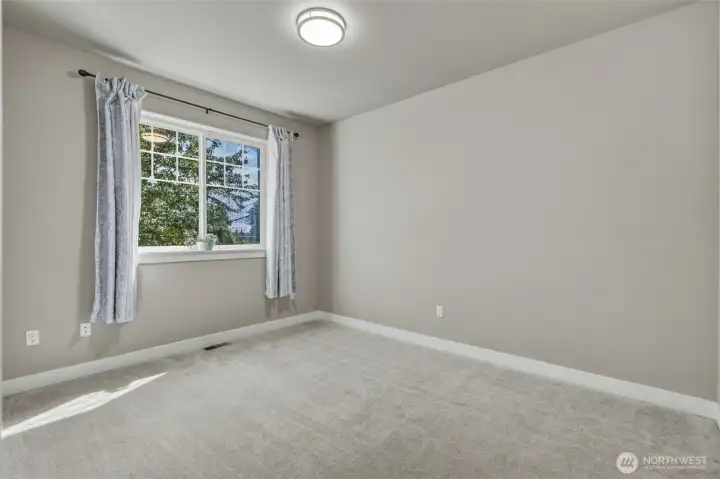 Bright secondary bedroom with abundant natural light.