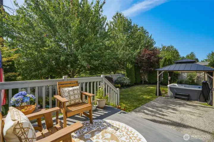 Private, fully fenced backyard with a deck, patio, gazebo, and hot tub.