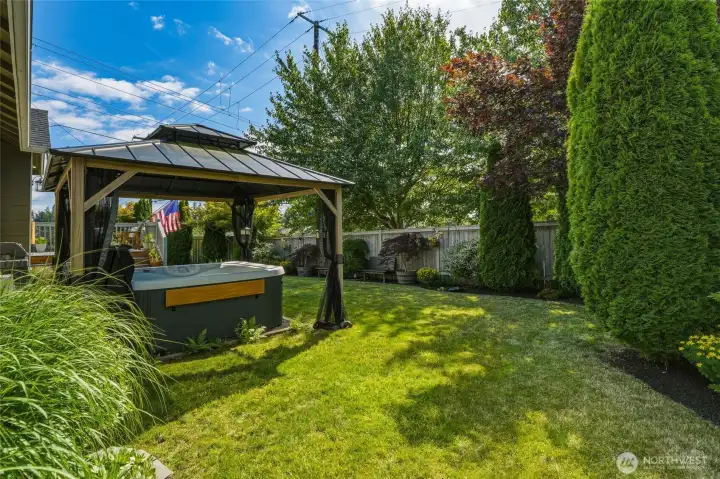 Private, fully fenced backyard with mature landscaping, lush lawn, and plenty of space to relax or entertain.