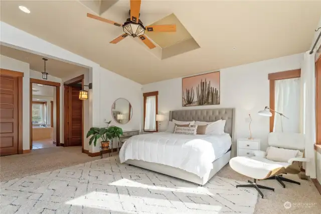 View 2 of upper level Primary Bedroom 1 w/ fireplace, vaulted ceilings, skylights, walk-in closet and glass sliding doors leading to the waterfront view deck.