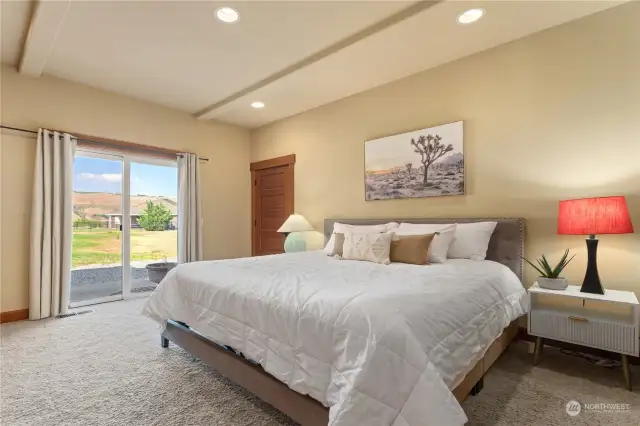 Lower level bedroom 4 w/ on-suite bath and glass sliding doors leading to the outdoor living area.