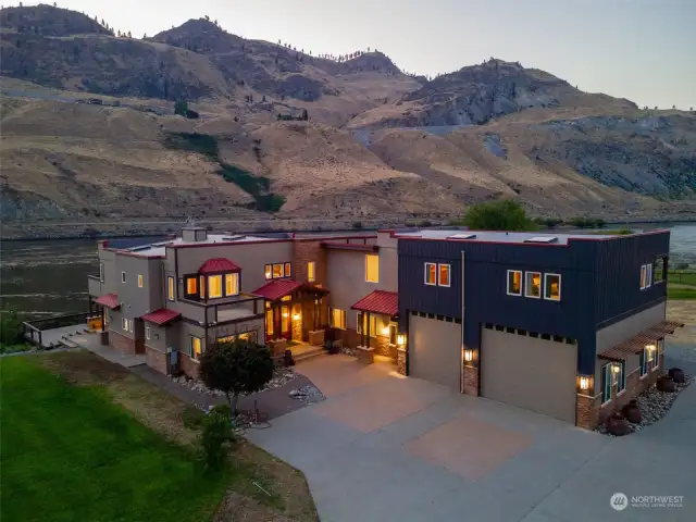 Exterior twilight view 5 of home and property w/ attached garage w/ oversized doors overlooking the Columbia River.