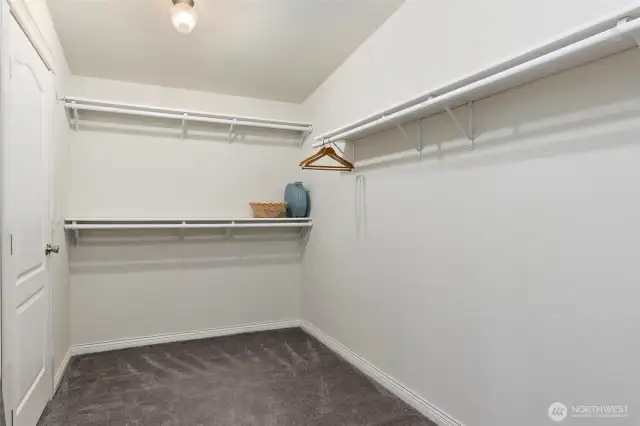 Primary walk in closet with door to bathroom and door to bedroom.