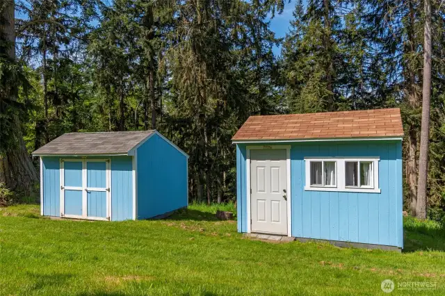 Two more sheds. The one on the right has windows, curtains!