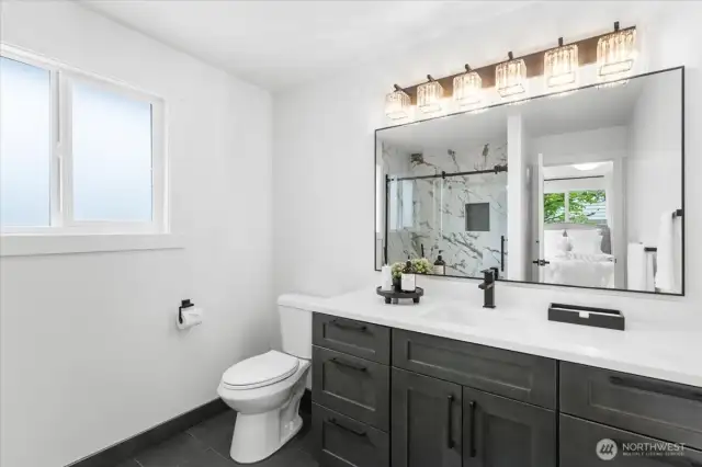 Primary bathroom with quartz countertops and tile flooring