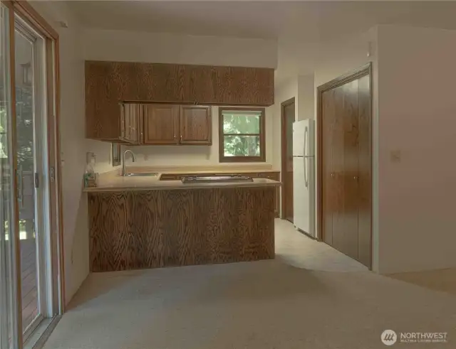 View from living room to the kitchen with large deck to the left.