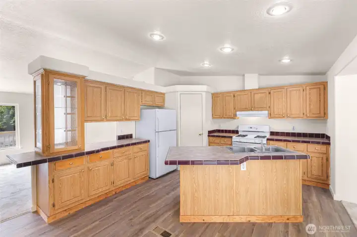 Convenient kitchen island and plenty of cabinets over tile countertops