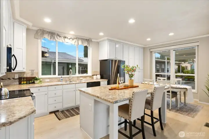 Open bright kitchen with island/bar for eating.