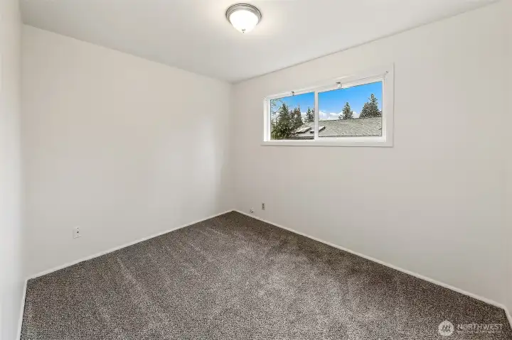 A comfortable and flexible bedroom offering space for a nursery, playroom, or quiet work-from-home retreat.