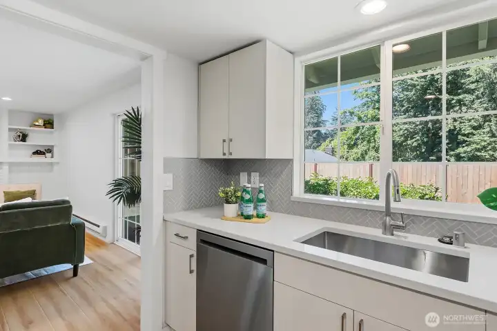 Big window in the kitchen overlooking the backyard bringing in natural light.