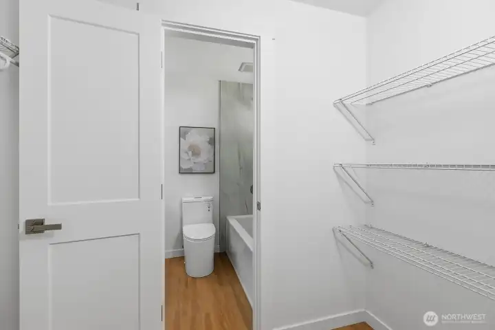Walk in closet for the primary bedroom with attached bathroom.