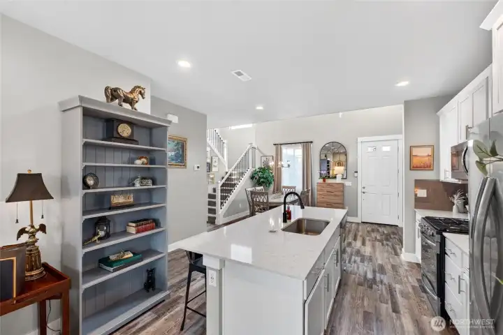 The stunning kitchen that features crisp white shaker-style cabinetry with soft-close doors & drawers, quartz counters, stainless appliances & an oversized island with generous seating. The stunning kitchen that features crisp white shaker-style cabinetry with soft-close doors & drawers, quartz counters, stainless appliances & an oversized island with generous seating.